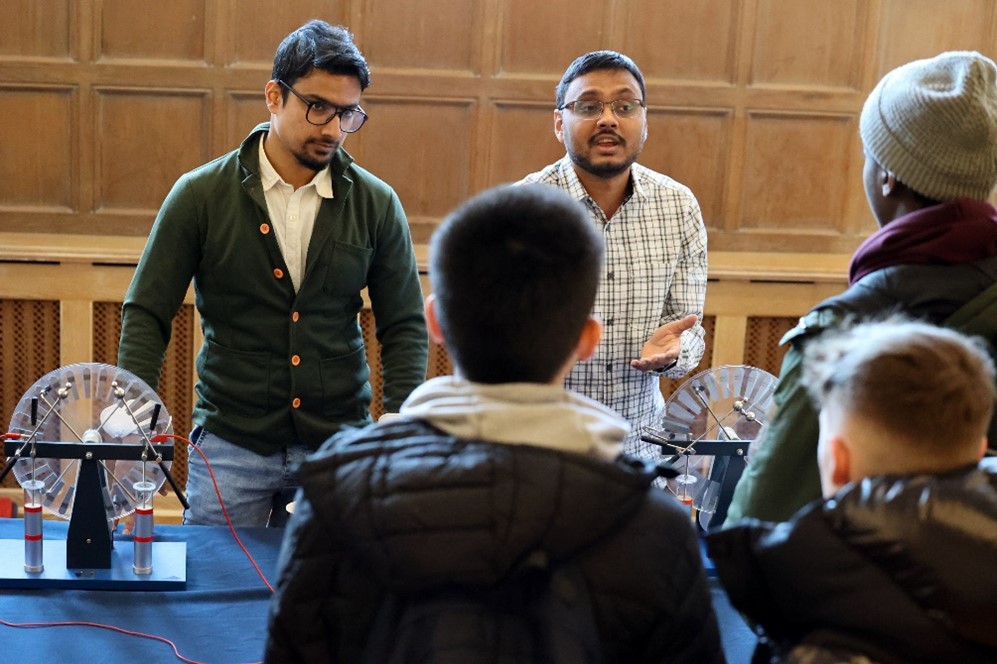 Two people explaining experiments to students.