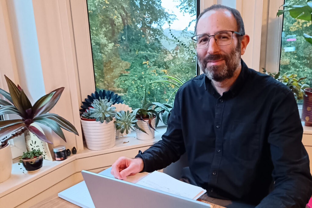A person posing for a photo sitting on a desk.