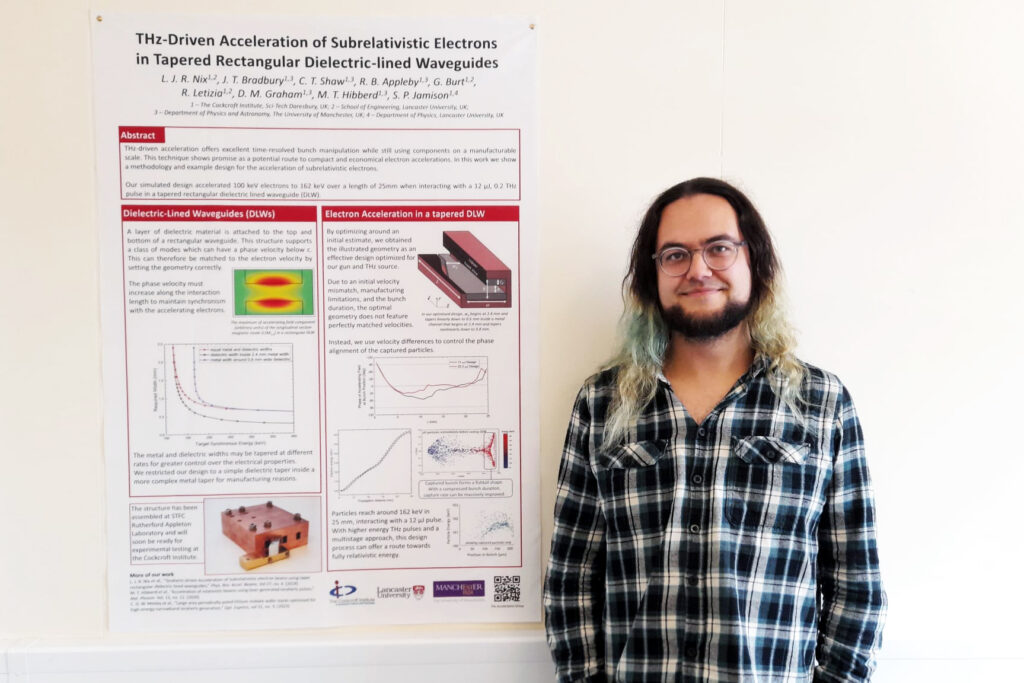 A person standing next to a poster.