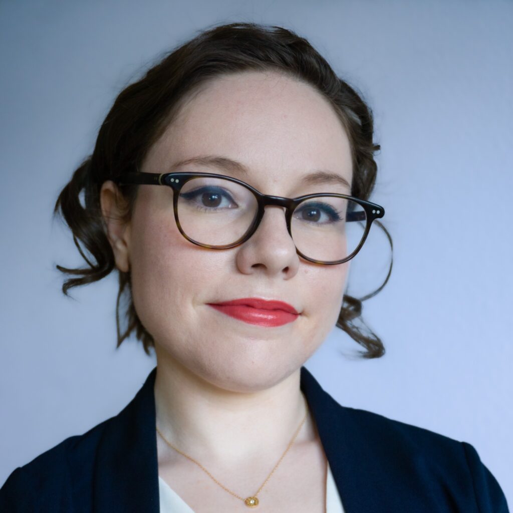 A person with glasses smiling into the camera.
