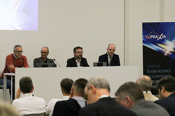 Panel members on a stage in front of an audience.