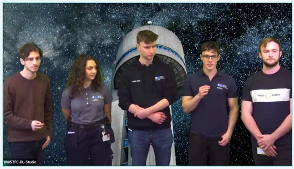 A group of people standing in front of an image of a tower in the night sky.
