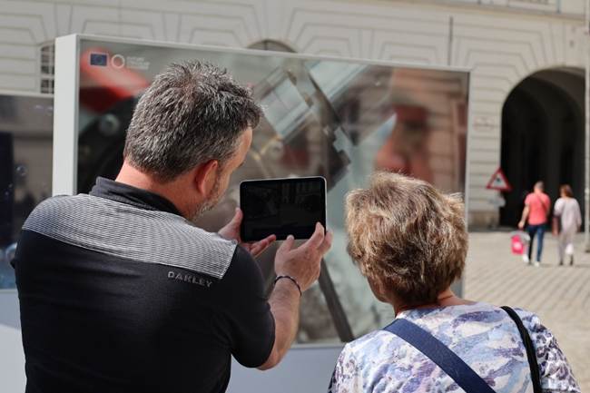 A person explaining something to another person on an iPAD.
