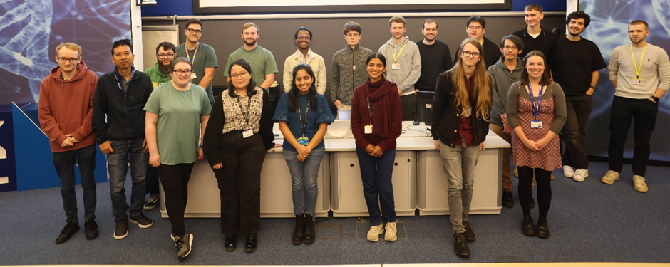 A group of people posing for a picture in a lecture theatre.