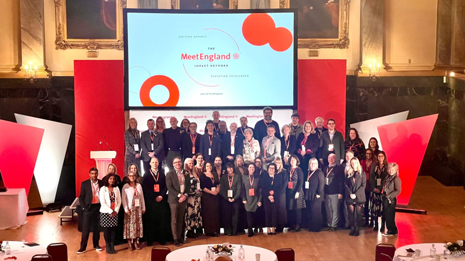 A large group of people posing for a picture on a stage.