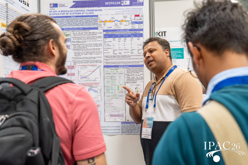 A person presenting a poster to two delegates.
