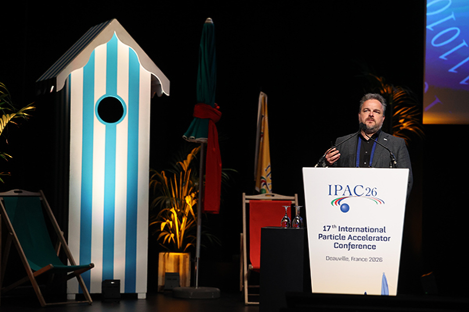 A person on a stage behind a lectern, presenting a talk.