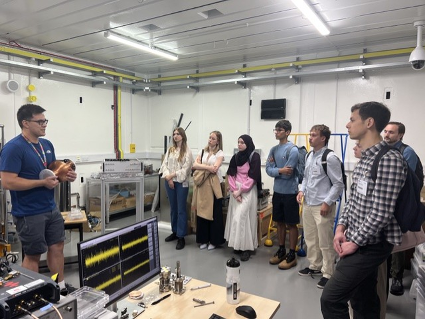 A person in a lab explaining something to a group of students.